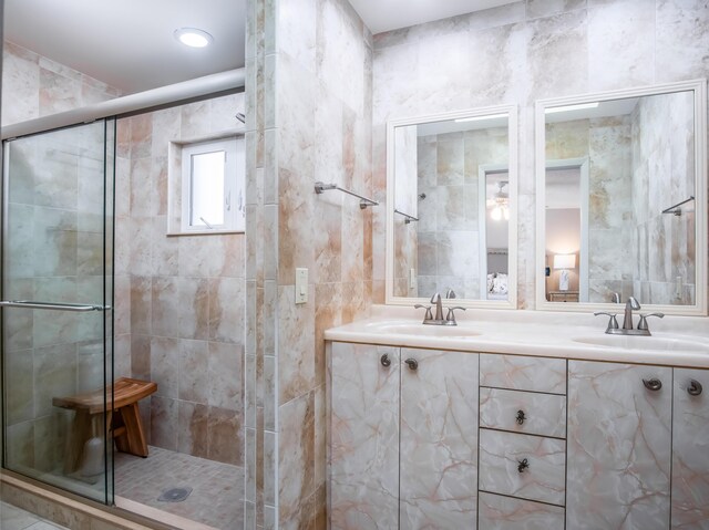 full bathroom featuring double vanity, a sink, and a shower stall