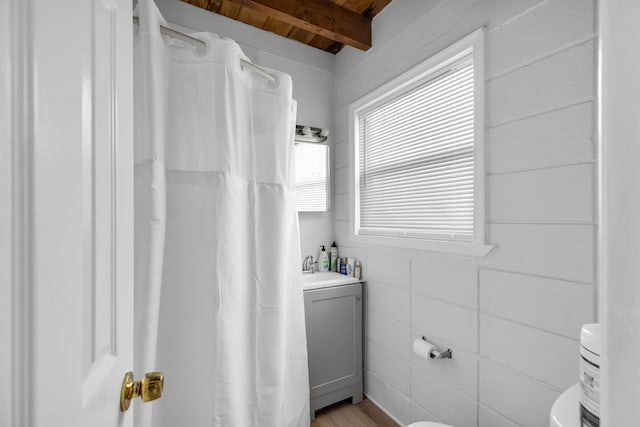 full bathroom with vanity, beamed ceiling, toilet, and curtained shower