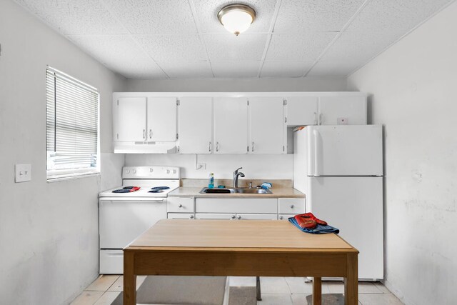 kitchen with under cabinet range hood, white appliances, white cabinetry, and a sink