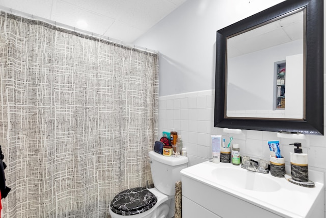 bathroom with vanity, tile walls, toilet, and a shower with curtain