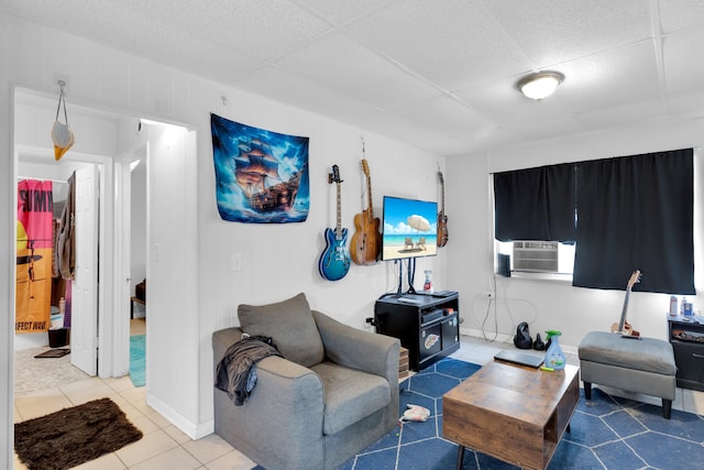 living room with tile patterned floors, cooling unit, a paneled ceiling, and baseboards