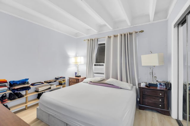 bedroom featuring light wood-type flooring and beamed ceiling