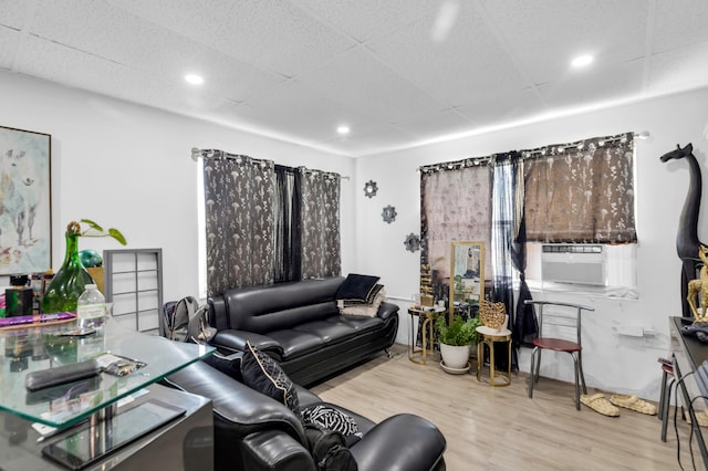 living area with recessed lighting, cooling unit, a paneled ceiling, and wood finished floors