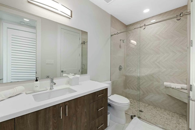 bathroom featuring vanity, toilet, and a stall shower