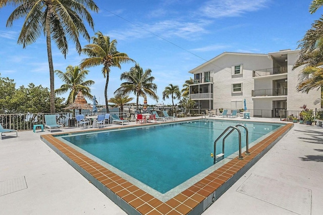 pool with a patio and fence