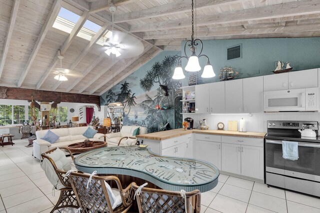 kitchen with pendant lighting, stainless steel electric range oven, white microwave, open floor plan, and white cabinetry