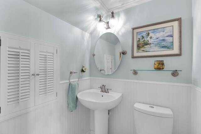 bathroom with a sink, a wainscoted wall, and toilet