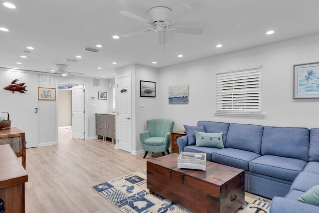 living room featuring a ceiling fan, visible vents, baseboards, recessed lighting, and light wood-style floors