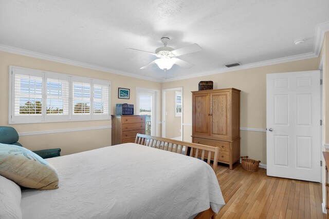 bedroom with visible vents, ceiling fan, baseboards, ornamental molding, and light wood-style floors