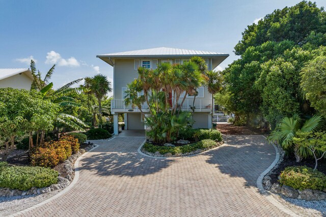 coastal inspired home featuring decorative driveway