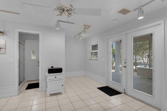 entryway with a ceiling fan, french doors, rail lighting, light tile patterned floors, and baseboards