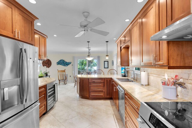 kitchen featuring ventilation hood, wine cooler, appliances with stainless steel finishes, a peninsula, and a sink