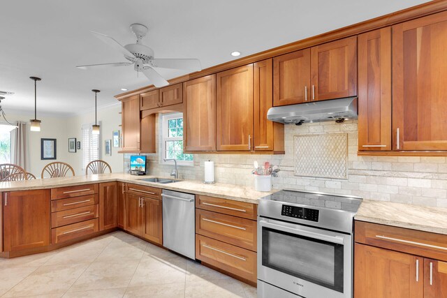 kitchen featuring under cabinet range hood, stainless steel appliances, brown cabinetry, and a sink