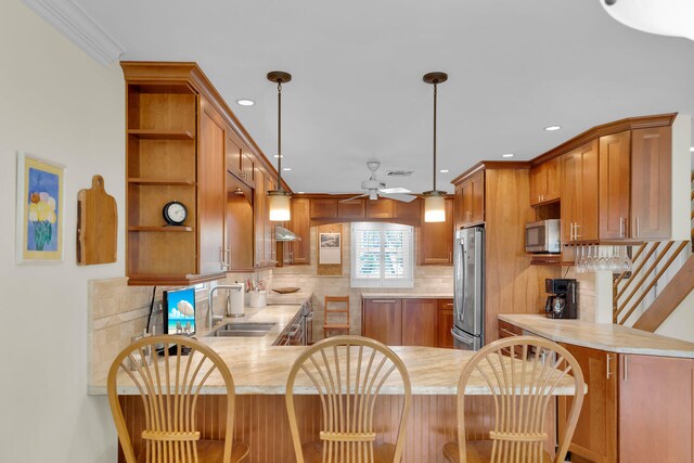 kitchen featuring a sink, appliances with stainless steel finishes, a peninsula, and light countertops