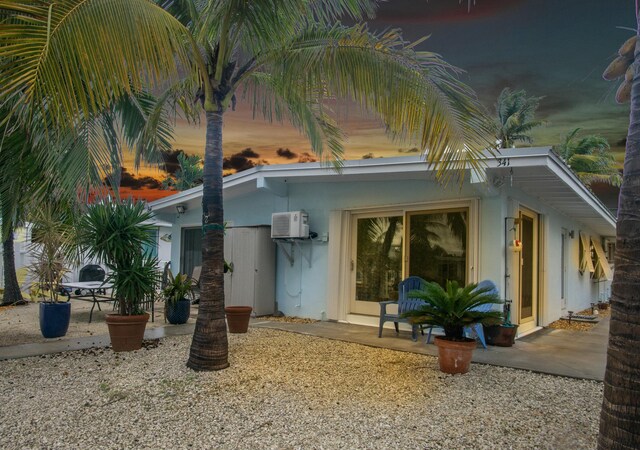 341 3rd St, Key Colony, FL 33051 - back of property featuring a patio area, an AC wall unit, and stucco siding