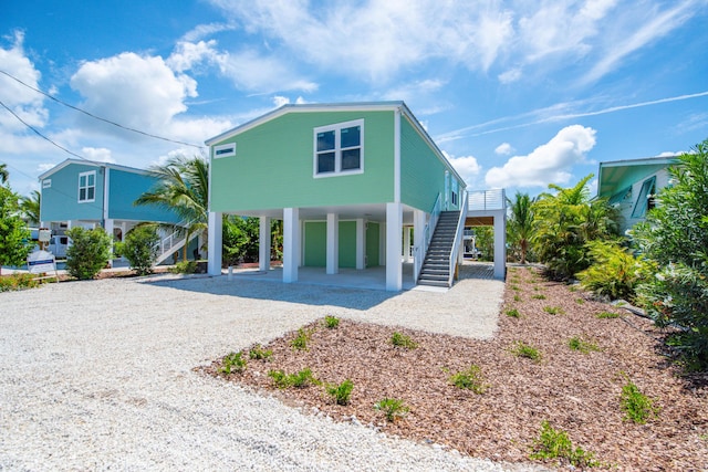 335 Pirates Rd, Little Torch, FL 33042 - coastal home with a carport, stairs, and gravel driveway