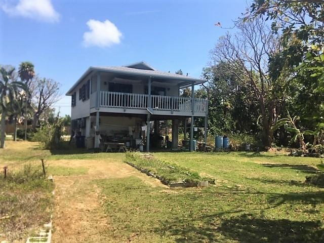 back of house featuring a yard, a deck, and a carport