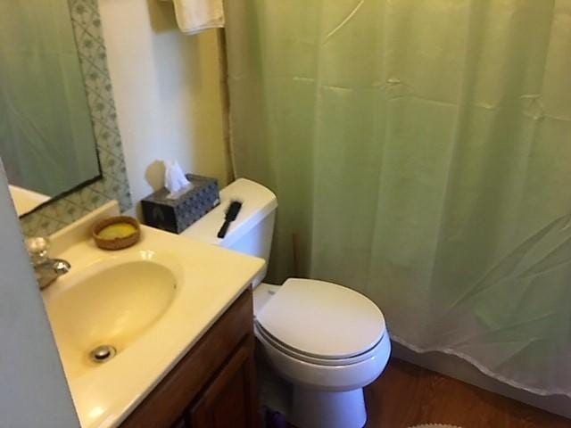full bathroom featuring vanity, wood finished floors, toilet, and curtained shower
