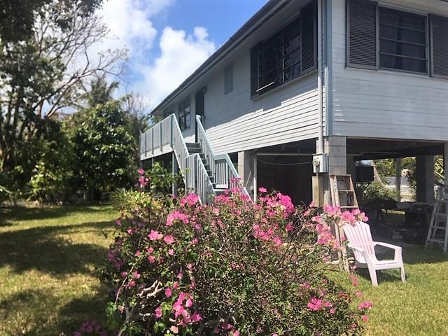 view of side of property featuring stairs and a yard