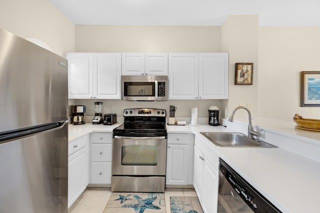 5081 Sunset Village Dr, Duck, FL 33050 - kitchen with stainless steel appliances, a sink, white cabinets, and light countertops