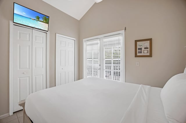 5081 Sunset Village Dr, Duck, FL 33050 - bedroom with vaulted ceiling, multiple closets, and light tile patterned floors
