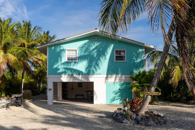 view of side of property with a carport and gravel driveway