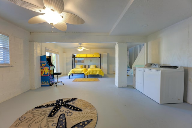 interior space with a ceiling fan, concrete block wall, independent washer and dryer, and concrete floors