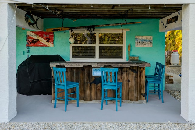 bar with a dry bar and finished concrete floors