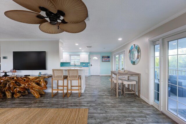 interior space with baseboards, ornamental molding, dark wood-type flooring, and recessed lighting