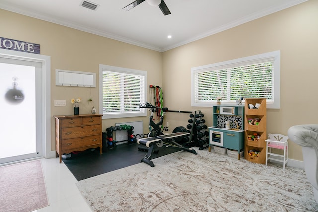 workout area featuring a ceiling fan, visible vents, and ornamental molding