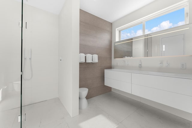 bathroom with tile walls, vanity, a stall shower, and toilet