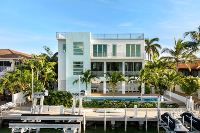 rear view of property featuring boat lift and a balcony