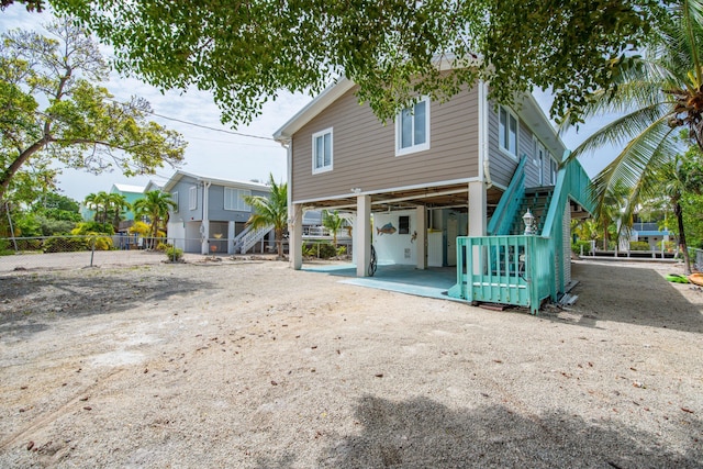 22878 Privateer Dr, Cudjoe, FL 33042 - rear view of house with a carport, stairway, and driveway