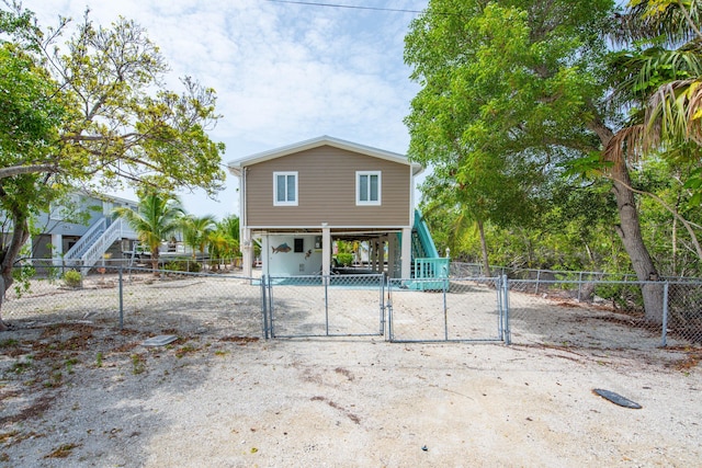 22878 Privateer Dr, Cudjoe, FL 33042 - rear view of property featuring a gate, a carport, concrete driveway, and a fenced front yard