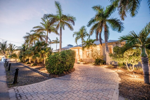 back of house featuring a water view, stairway, boat lift, and a patio area