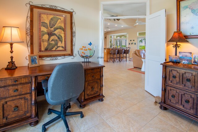 office area with light tile patterned floors and ceiling fan