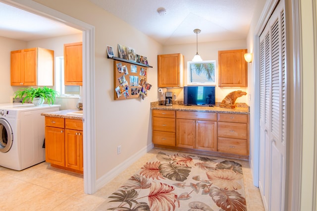 interior space featuring hanging light fixtures, baseboards, washer / dryer, and light tile patterned flooring