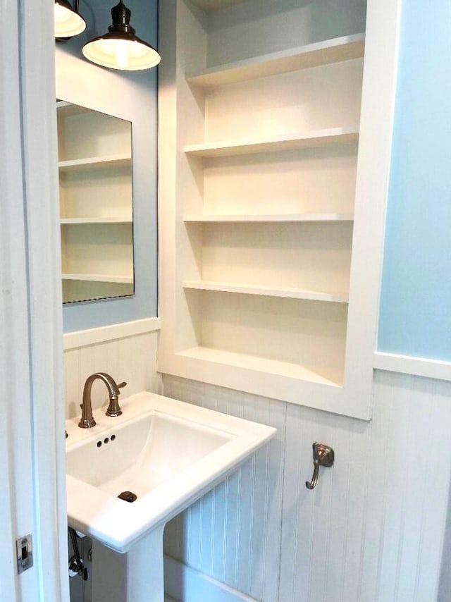 bathroom with built in shelves and wainscoting