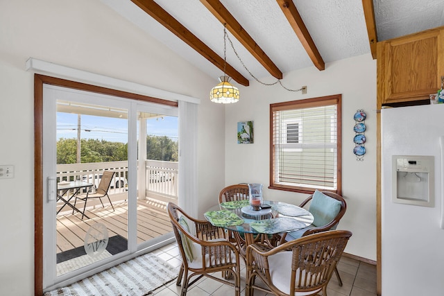 dining space featuring light tile patterned flooring, a textured ceiling, and vaulted ceiling with beams