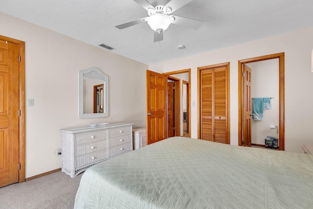 carpeted bedroom with a ceiling fan, baseboards, visible vents, and a closet