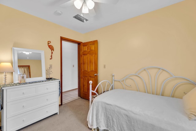 bedroom featuring visible vents, light colored carpet, and ceiling fan