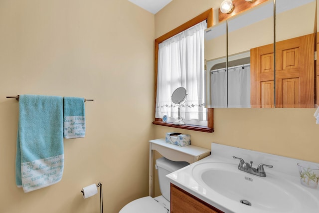 bathroom with toilet, a shower with shower curtain, plenty of natural light, and vanity