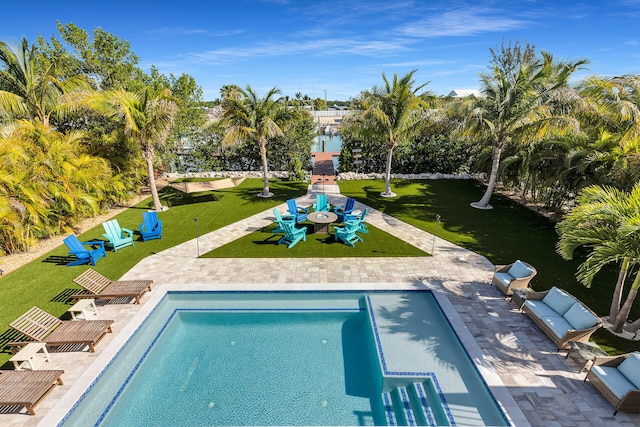 outdoor pool featuring a patio area and a yard