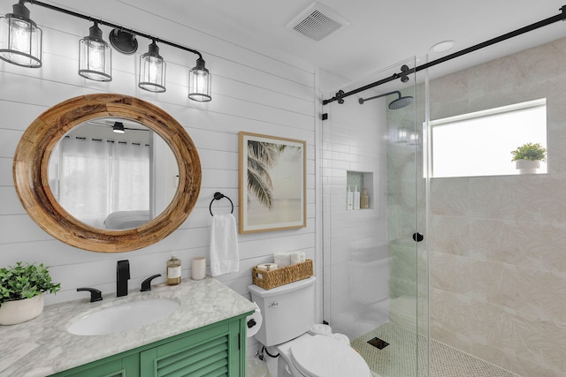 bathroom with a shower stall, vanity, visible vents, and toilet