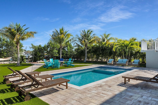 pool with a patio and a lawn
