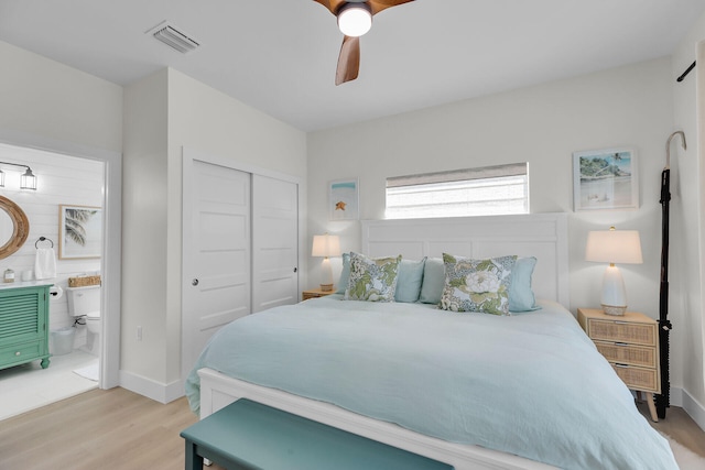 bedroom with visible vents, baseboards, a closet, light wood-style floors, and connected bathroom