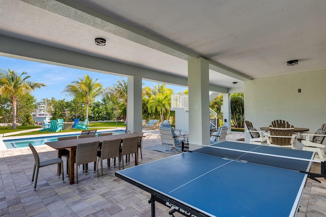 view of patio with stairway, outdoor dining area, and an outdoor pool