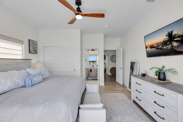 bedroom featuring visible vents, a closet, a ceiling fan, and light wood-style floors