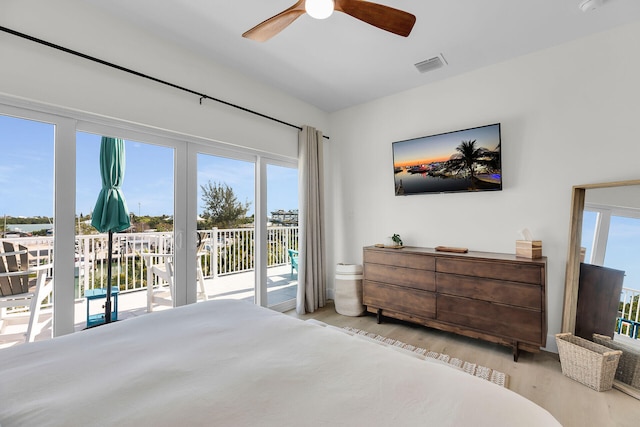 bedroom with visible vents, access to outside, multiple windows, and wood finished floors