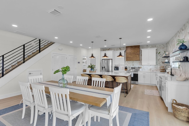 dining room with recessed lighting, stairs, light wood finished floors, and visible vents